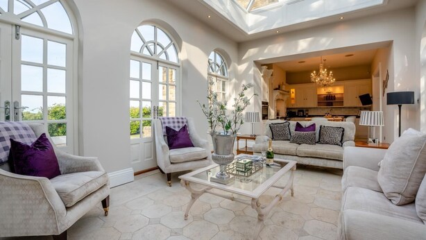A spacious living room with a high ceiling and large windows, a central coffee table, and a sofa set. - 4 Bed in Beamish (oc-o32025) (Beamish)