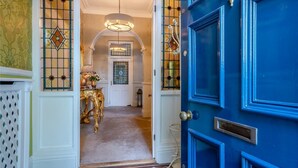 A grand hallway with a blue door, a chandelier, and a decorative lamp. - 4 Bed in Beamish (oc-o32025) (Beamish)