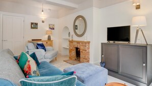 Un salon comprenant un canapé, un téléviseur, une cheminée et un meuble.
