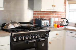 Eine Küche mit Gasherd, Toaster und Wasserkocher auf der Arbeitsplatte.