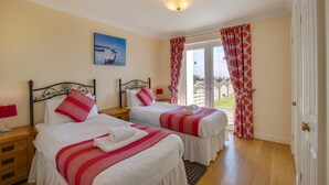 Habitación de hotel con dos camas, un cuadro y vistas por la ventana.