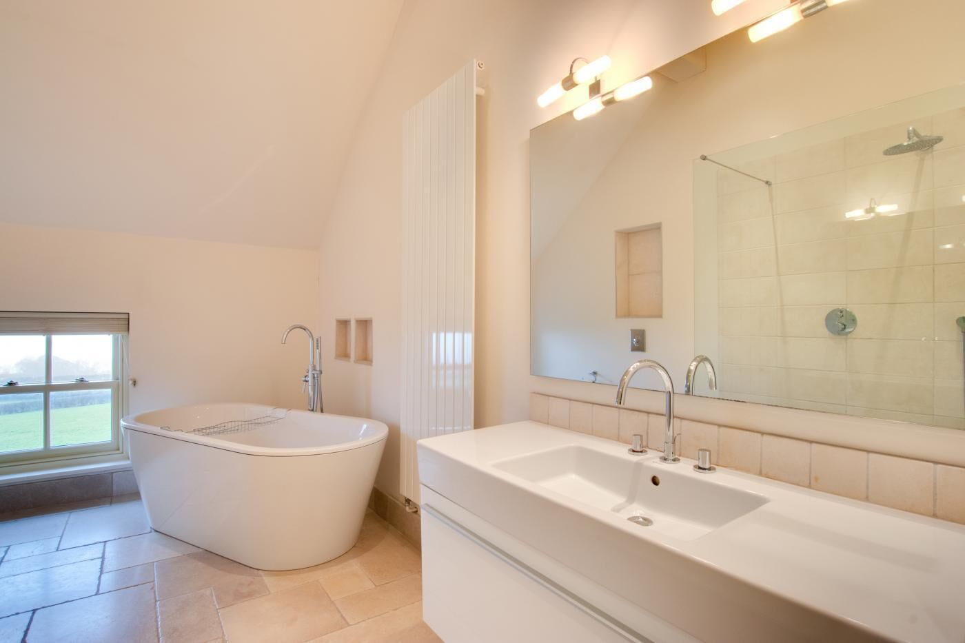 Une salle de bain moderne avec une baignoire sur pieds, un grand meuble-lavabo avec un miroir et un espace douche.