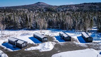 A remote cabin area with multiple cabins, each with a separate entrance and a blue roof.