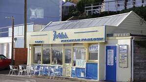 Een café met terras en een bord waarop een ijssalon wordt aangekondigd.