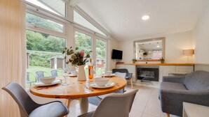 Una cucina moderna con zona pranzo, ampie finestre e televisione a schermo piatto.