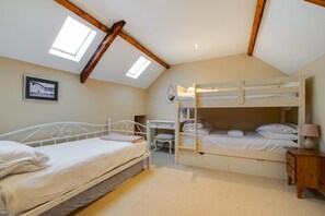 A bedroom with a bunk bed, a desk, and a chair.