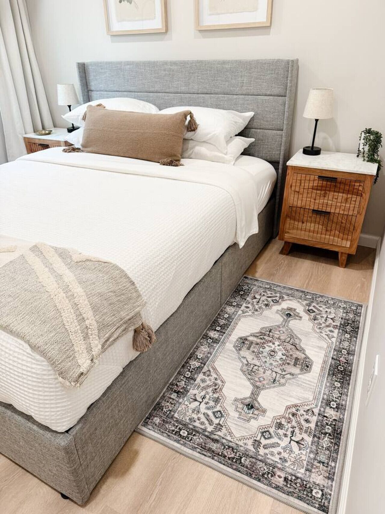 A bedroom with a bed, bedside tables, a rug, and a nightstand.