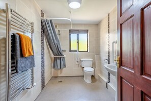A compact bathroom with a shower, toilet, and sink. - 1 Bed in Isel (oc-b32075) (Setmurthy)