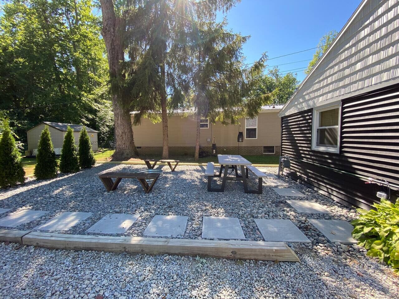 A patio area with picnic tables and a stone pathway.