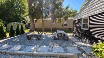 A patio area with picnic tables and a stone pathway.
