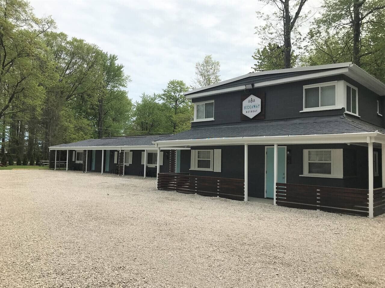 Une rangée de bâtiments d’un seul étage, dotés d’un espace extérieur couvert, probablement un lieu de retraite ou un terrain de camping.