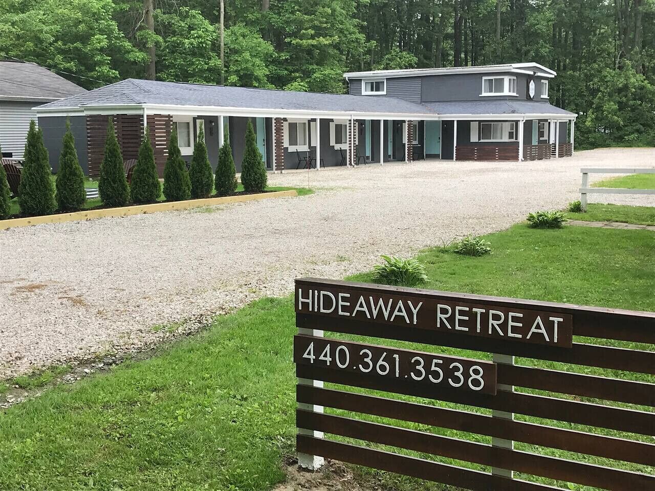 A building labeled "Hideaway Retreat" with a gravel driveway and a grassy area in front.