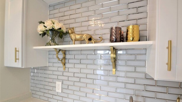 A kitchen with white cabinets, a white backsplash, and gold hardware. - King Glamour #8, Walk to the Strip, A/C, WiFi (Geneva)