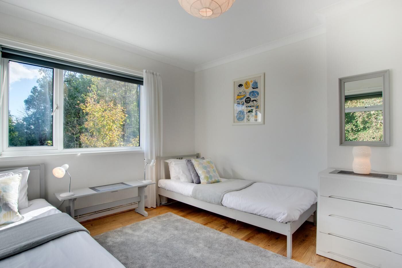 A modern bedroom with a bed, bedside table, and a desk.