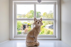A sculpture of a fox on a windowsill with a view of a garden and houses. - 2 Bed in Warton (oc-b31819) (Warton)