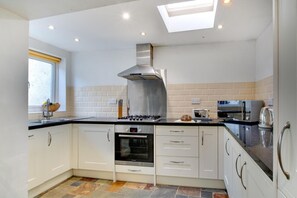A modern kitchen with white cabinets, a Bosch oven, a gas stove, a toaster, and a kettle. - 2 Bed in Mumbles (oc-hh382) (The Mumbles)