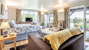Ein Schlafzimmer mit Bett, Fernseher, Sessel und Sofa.