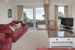 Ein Wohnzimmer mit einem roten Sofa, einem weißen Couchtisch und einem Fernseher.