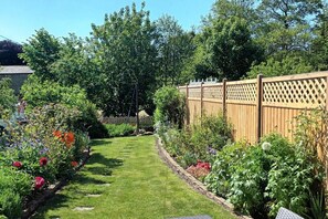 A garden with a paved path, wooden fence, and various plants. - 2 Bed in Caldbeck (oc-a32049) (Caldbeck)