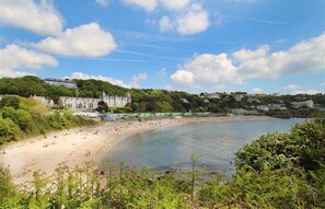 A coastal beach with a castle-like building in the background.