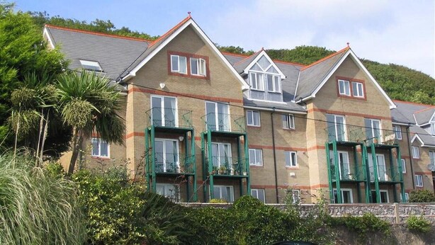 A row of two-story buildings with a consistent architectural style, featuring a pitched roof and a brick facade. - 1 Bed in Langland (oc-hh147) (Newton)