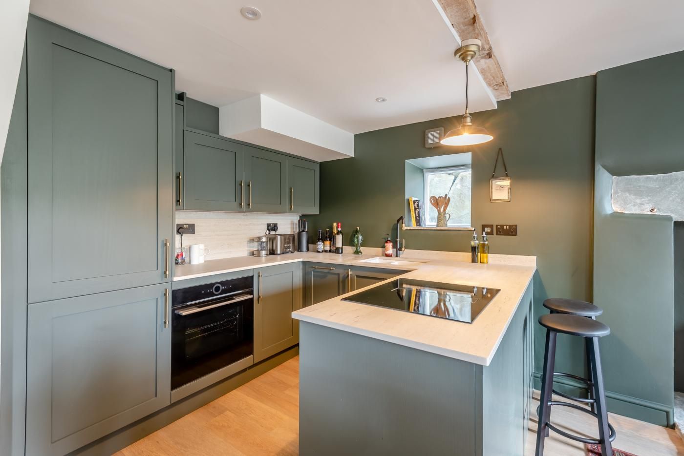 A modern kitchen with a central island, built-in appliances, and a bar stool.