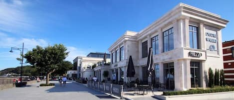 Een gebouw aan de kust met een restaurant genaamd "Oyster Wharf" en "Prezzo" op de begane grond.