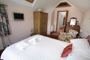 A bedroom with a bed, a wooden wardrobe, a chair, a mirror, and a television. - 2 Bed in Mumbles (oc-hh120) (The Mumbles)
