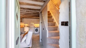 A hallway leading to a bedroom with a white sofa, a washing machine, and a staircase. - 1 Bed in Harlech (oc-t32043) (Harlech)