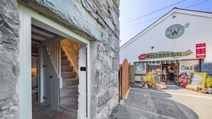 A rustic building with a stone exterior and a wooden staircase leading to an interior. - 1 Bed in Harlech (oc-t32043) (Harlech)