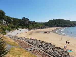 A beach with rocky areas, a sandy shore, and a few people.