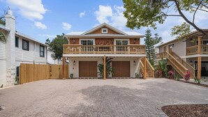 A two-story house with a balcony, a garage, and a paved driveway. - The Augustine Suite l Heated Pool  l Walk to DNTN (St. Augustine)