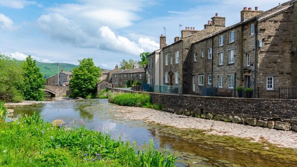 A stone bridge over a river, with stone buildings on one side and greenery on the other. - 2 Bed in Gayle (oc-ds670) (Hawes)