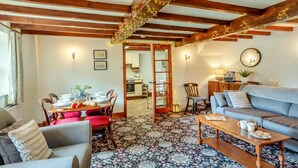 A cozy living room with a wooden ceiling, a dining area with a table set, and a sofa with a floral rug. - 2 Bed in Gayle (oc-ds670) (Hawes)