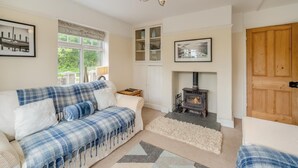 A cozy living room with a sofa, a fireplace, and a wooden door.