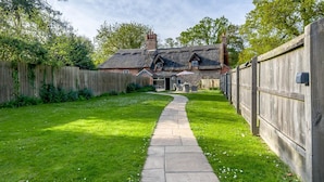 A thatched-roof house with a stone pathway leading to a door. - 2 Bed in Hanworth (oc-h32041) (Hanworth)