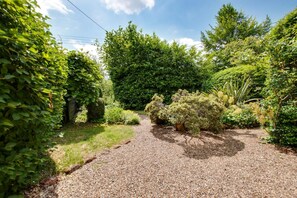 A gravel pathway leading through a garden with various shrubs and trees. - 2 Bed in Peasenhall (oc-sfrsc) (Peasenhall)