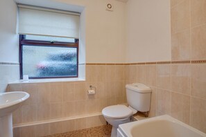 Ein Badezimmer mit Toilette, Waschbecken und Badewanne.
