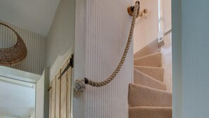 Eine Treppe mit beige farbenen Teppichstufen führt zu einer Zwischenebene mit einer weißen Tür.