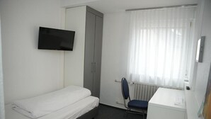 A small, clean room with a single bed, a desk, a chair, a television, and a wardrobe. - Weber Residenz (Mannheim)