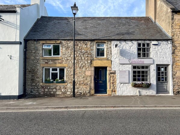 A stone building with a sign for 'Lia Graham Haircare' on the front.