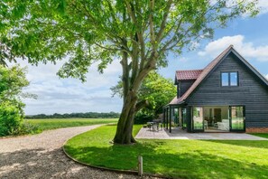 A house with a large tree in front, a gravel path, and a grassy area. - 1 Bed in Sudbourne (oc-tgs) (Sudbourne)