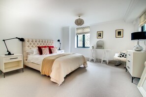 A bedroom with a large bed, bedside tables, a desk, and a chair. - 4 Bed in Thorpeness (oc-barrh) (Thorpeness)