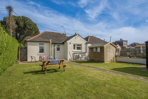 A residential property with a grassy yard, a wooden bench, and a small shed. - 2 Bed in Dymchurch (oc-s31998) (Dymchurch)