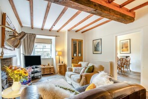 Ein Wohnzimmer mit Kamin, Sofa und Fernseher.