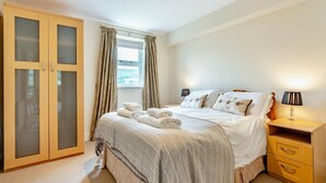 A bedroom with a bed, bedside tables, a wardrobe, and a window with curtains. - 3 Bed in Hawes (oc-ds967) (Hawes)