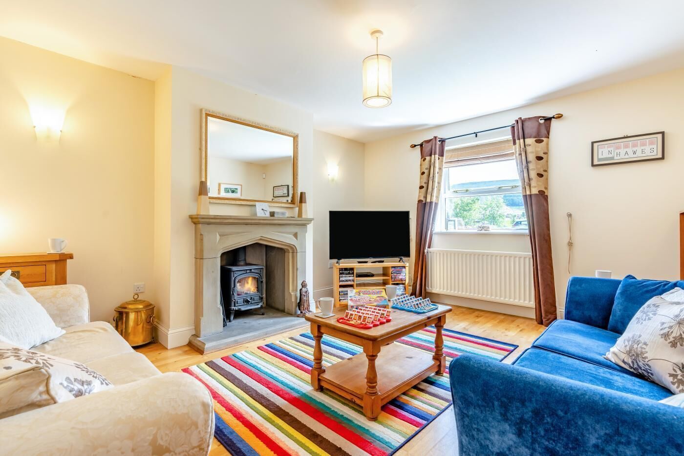 A living room with a fireplace, television, and a blue sofa.