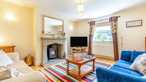 A living room with a fireplace, television, and a blue sofa. - 3 Bed in Hawes (oc-ds967) (Hawes)