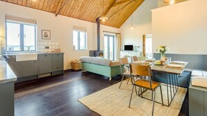 A modern kitchen with a wooden ceiling, a dining area with a table and chairs, and a cozy seating area with a sofa. - 1 Bed in Wickhambrook (oc-tosh) (Wickhambrook)
