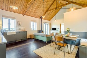 A modern kitchen with a wooden ceiling, a dining area with a table and chairs, and a cozy seating area with a sofa. - 1 Bed in Wickhambrook (oc-tosh) (Wickhambrook)